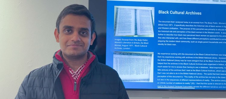 Varun Raj, biology major, presents his project on the Black Cultural Archives on a monitor in the M Street gallery.
