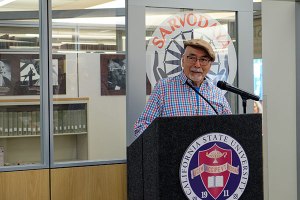 Juan Filipe Herrera speaks at the podium in front of the Gandhi Center in the Fresno State Library.