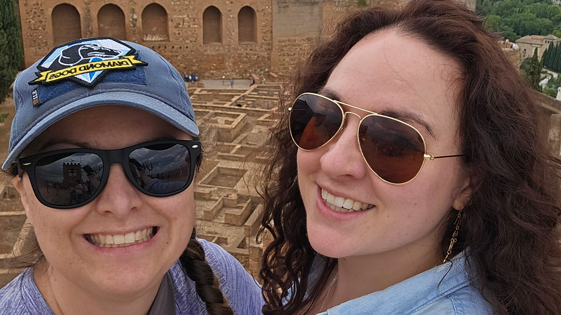 Two women pose for a photo in front of ancient ruins in Spain.