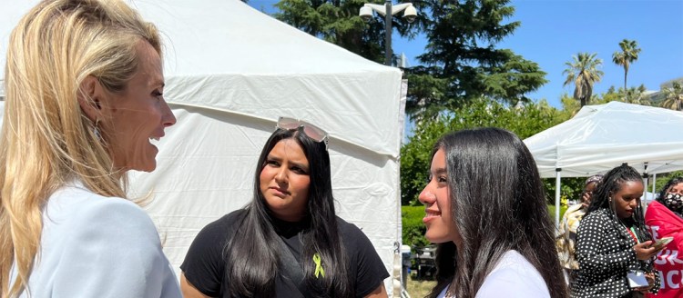 Two students look at a woman