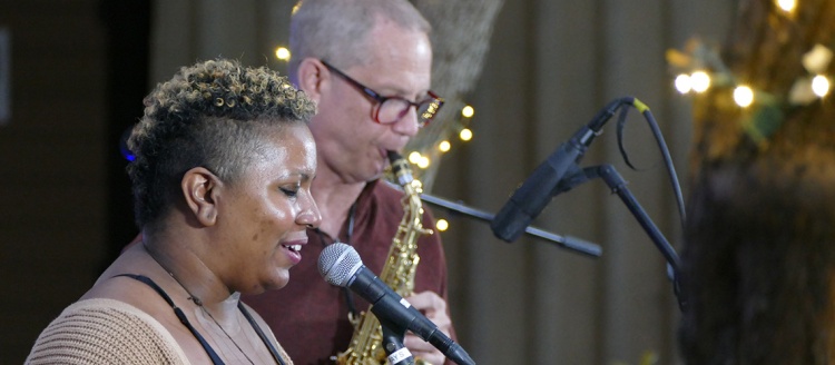 Falita Hicks at a microphone and Benjamin Boone on a saxophone.