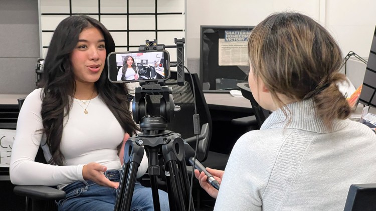 Jazmin Alvarado talks to a reporter about the Journalist of Color Training Program inside The Collegian newsroom.