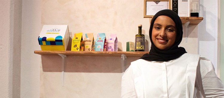 Asmaa Althami stands in front of her display at the 2024 Senior Art Show