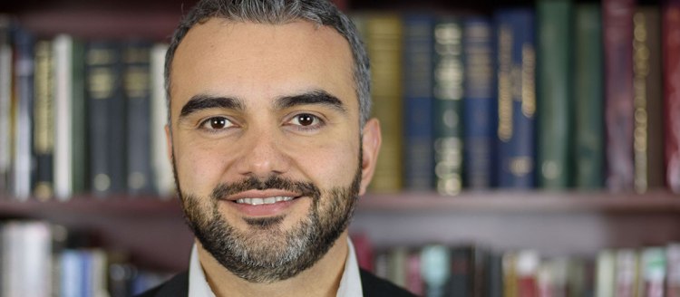 Dr. Simon Maghakyan headshot in front of a book case