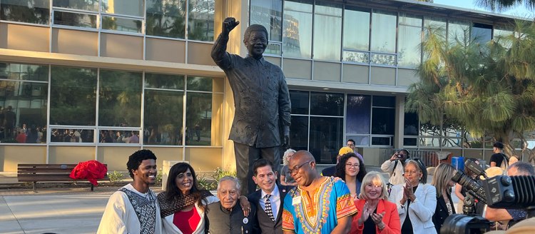 Media and dignitaries gather around the newly unveiled Nelson Mandela sculpture in the Fresno State Peace Garden.