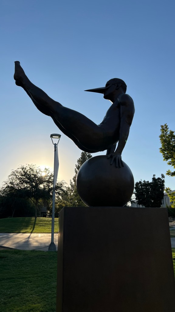 Equilibrista 90 Monumental - 2005 | 3.9 x 1.5 x 4.2 ft - Able to perform actions and movements that seem impossible, this sculpture symbolizes the perfection of the human body. The mask invites us to project ourselves onto it as it reminds us of the coexistence between humans and their environment.