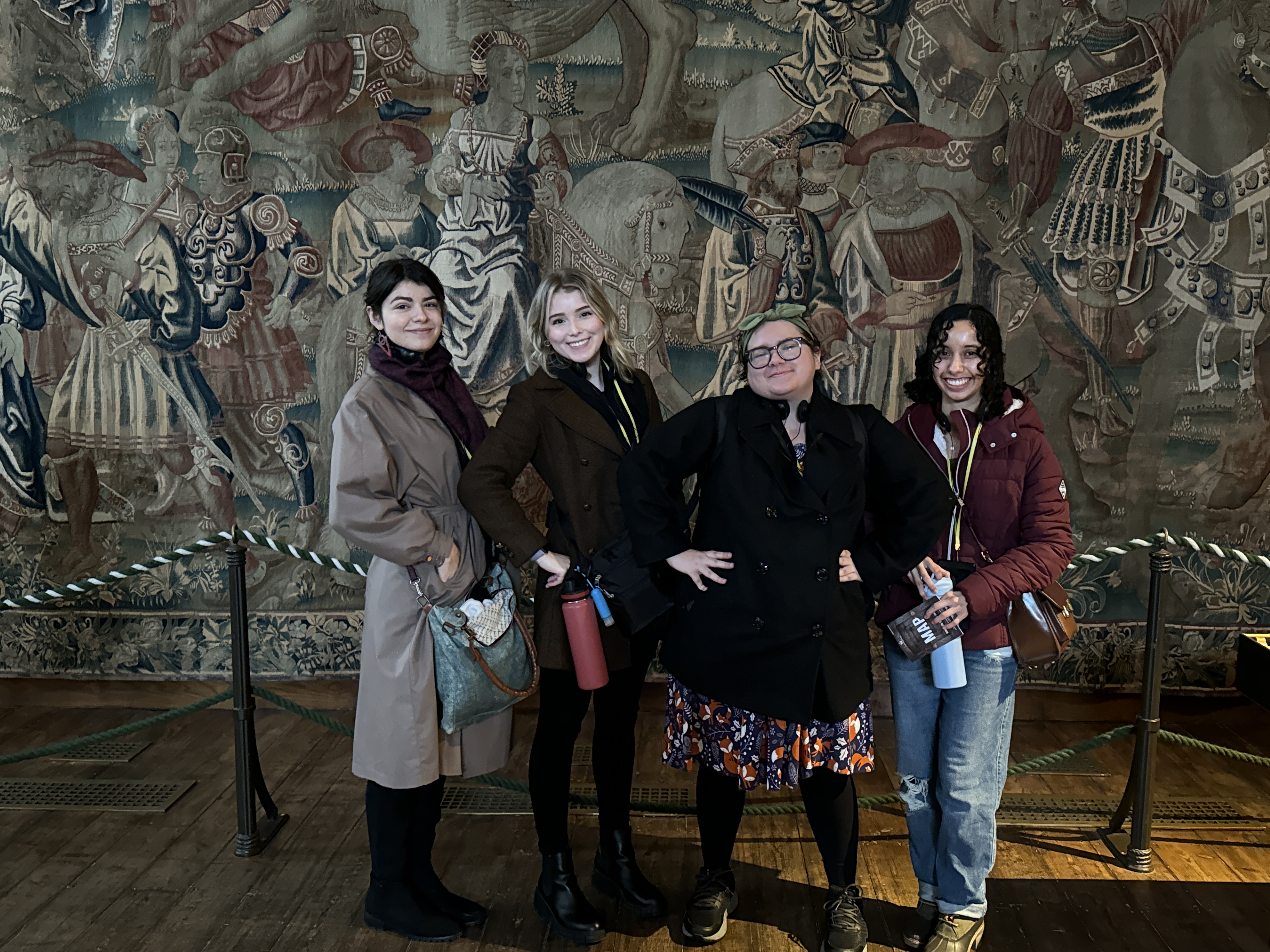 Fresno State students in front of a tapestry.