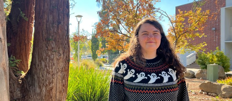 Keira Colleluori in front of fall foliage.
