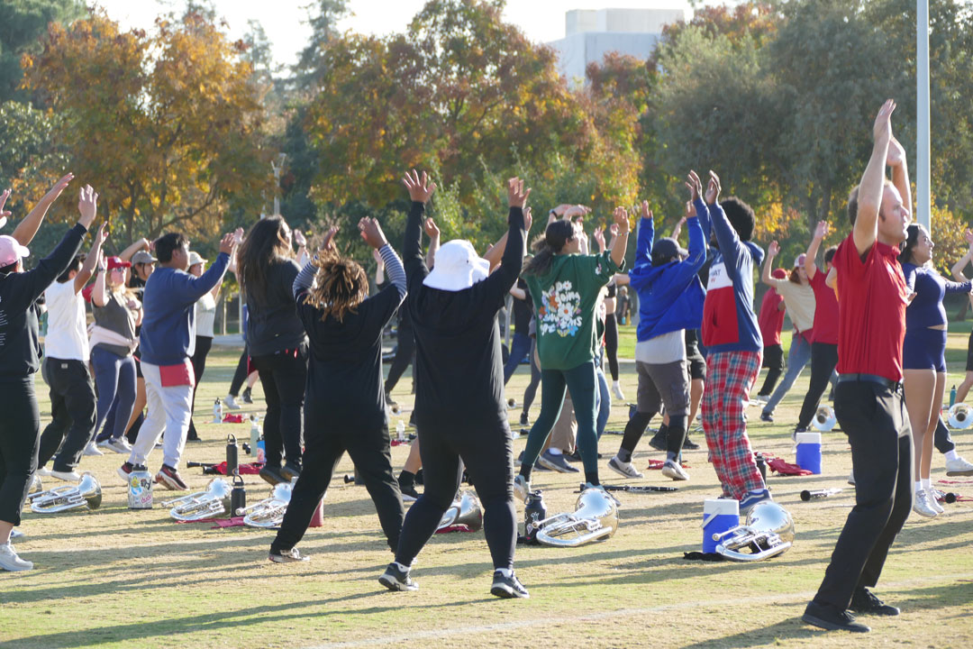 The Bulldog Marching Band members do jumping jacks as part of their extensive warm up and fitness regiment.