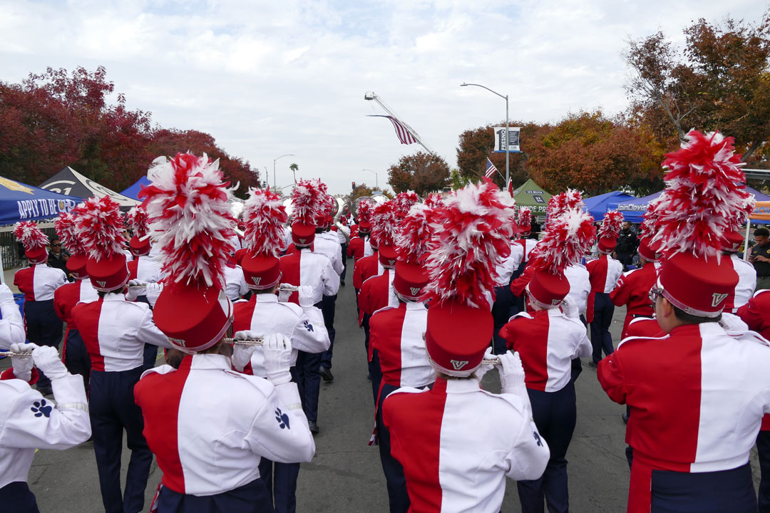 A view from the back of the Bulldog Marching Band as they march under the American flag during the Veterans Day Parade.