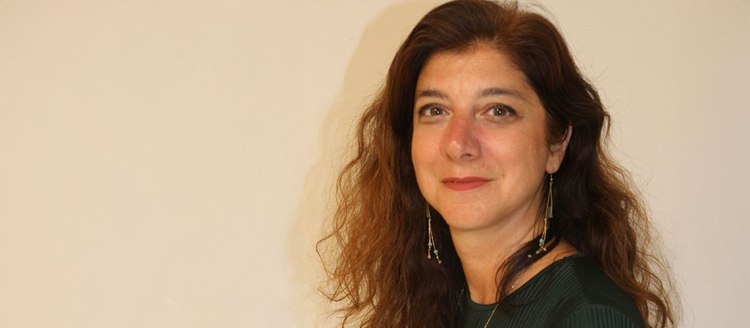 Dr. Talin Suciyan in front of a tan wall.