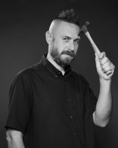 David A. Romero in black and white holding a hammer