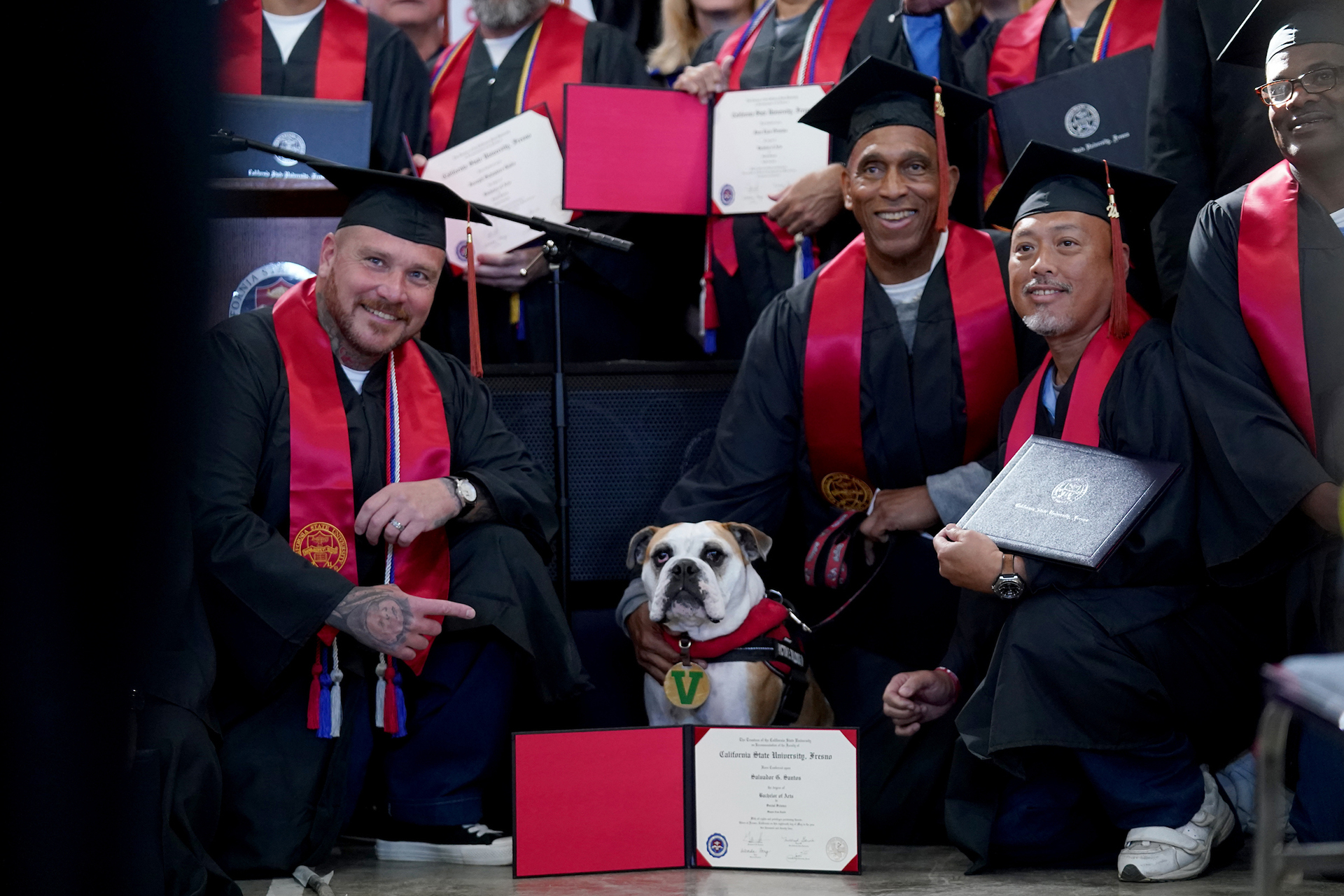 Incarcerated graduates pose with Victor E. Bulldog.