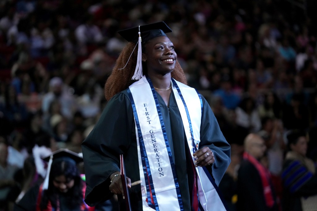 A woman graduate wears the "First Generation" stole.