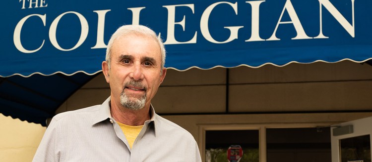 Dennis Morgigno in front of The Collegian sign at Fresno State.