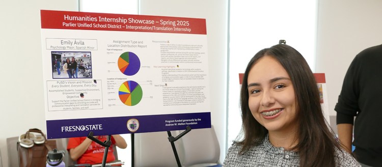 Emily Aliva stands in front of her display Internship Showcase display board.