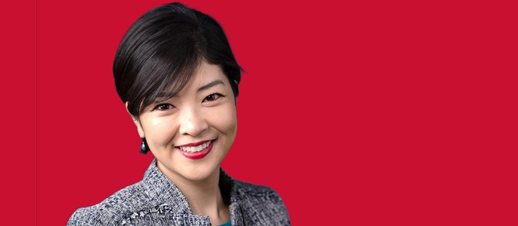 Professor Oya Hanoyo in front of a red background.
