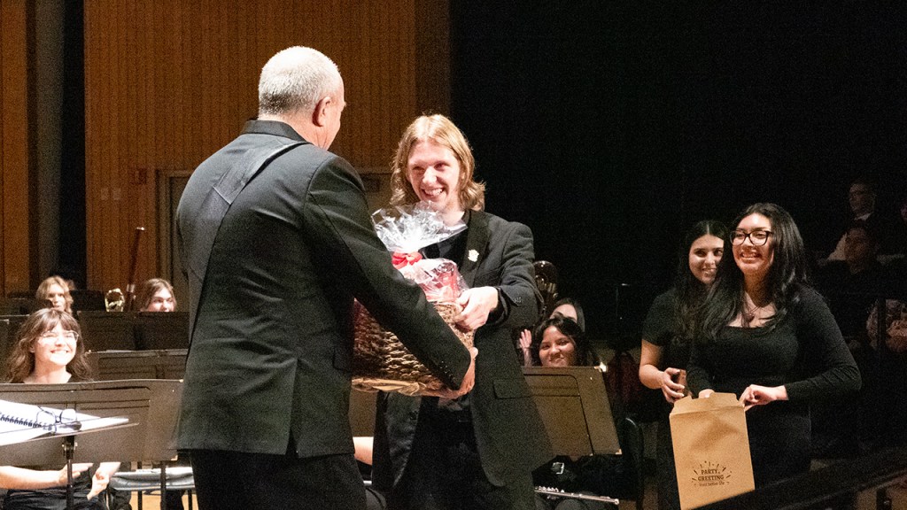 A student presents Dr. Gary Gilroy with a gift basket at his final concert.
