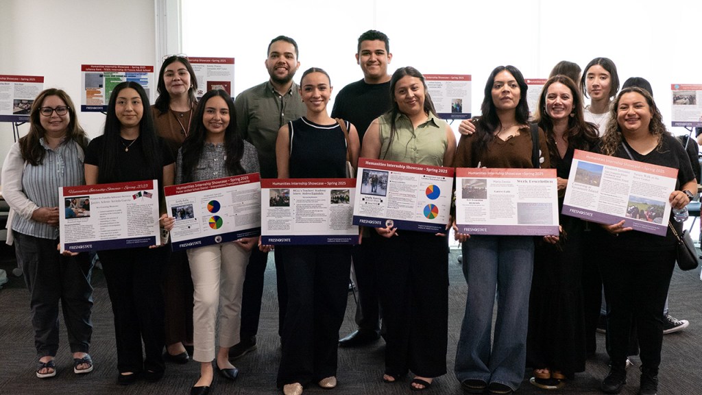 The Department of Modern and Classical Languages and Literatures (MCLL) students and faculty pose for a photo with their presentation boards at the Humanities Internship Showcase.